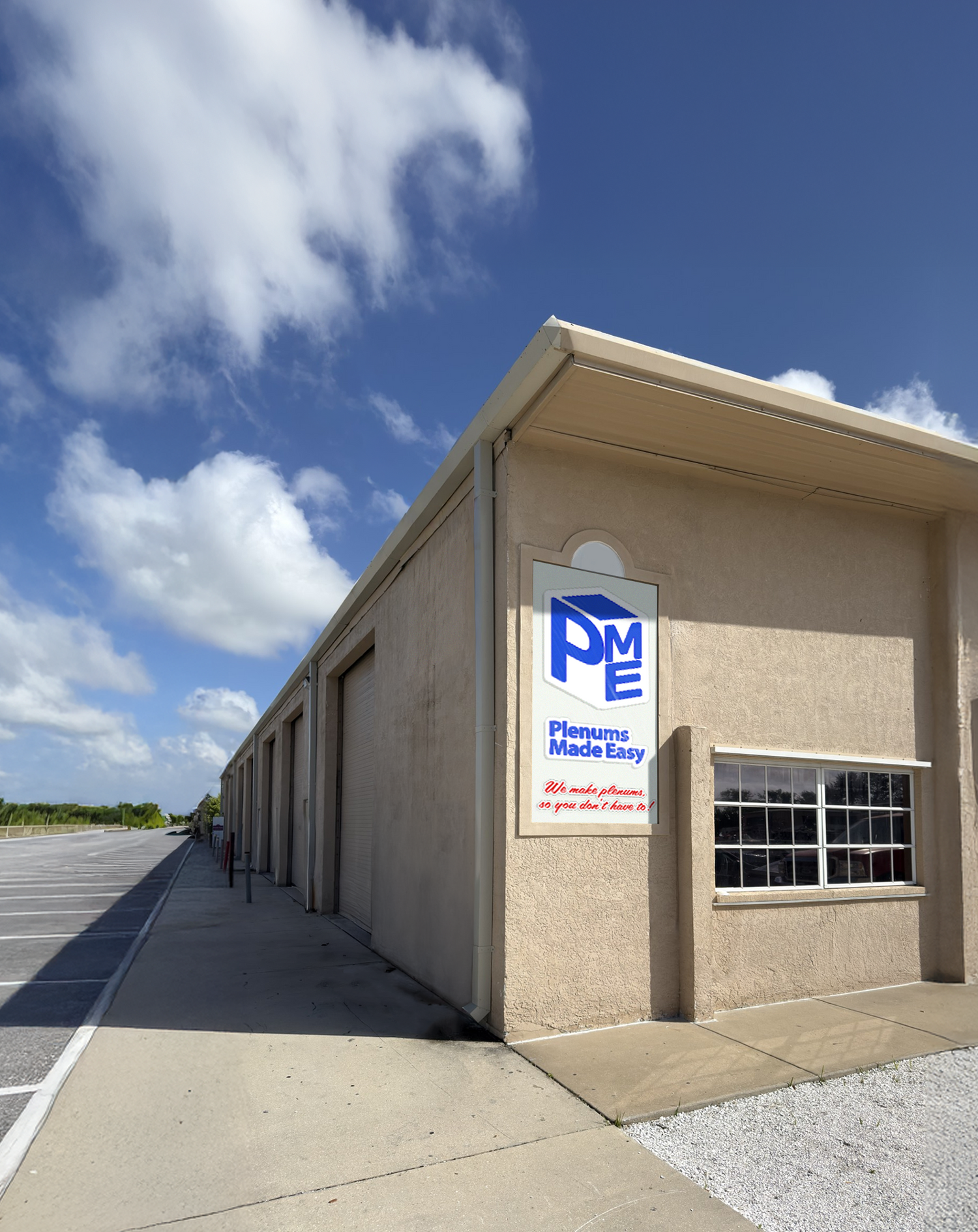 Building exterior with a sign for 'Plenums Made Easy' against a blue sky.