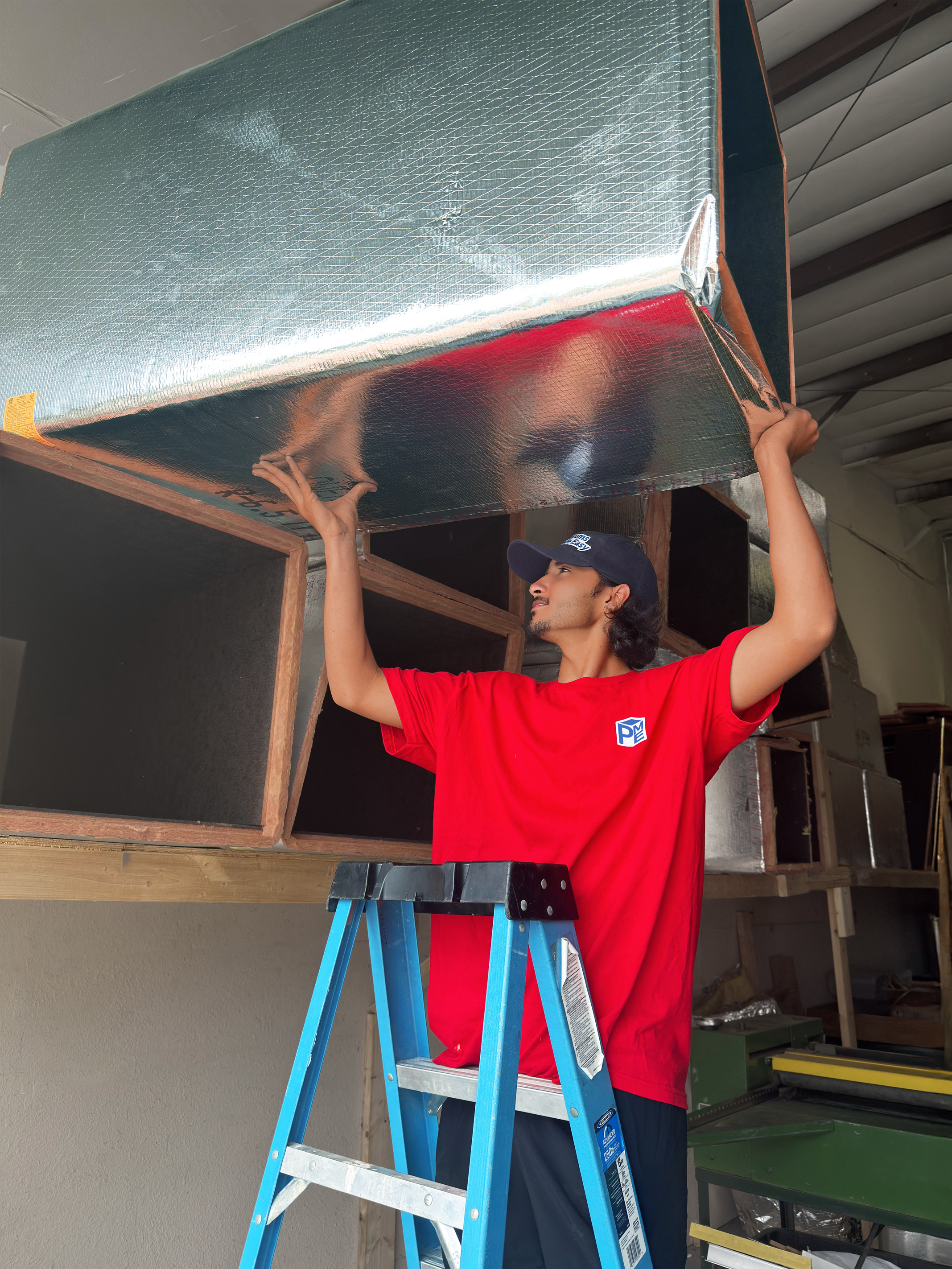 Person adjusting a large duct board plenum on a shelf